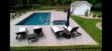 Backyard pool area with lounge chairs and a small shed.