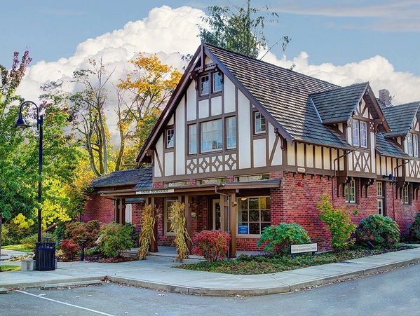red brick building with trees and flowers around it