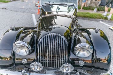 Front view of a shiny classic black car with chrome details.