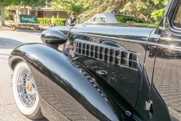 Close-up of a shiny black vintage car with whitewall tires.