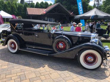 Vintage black convertible car at an outdoor event.