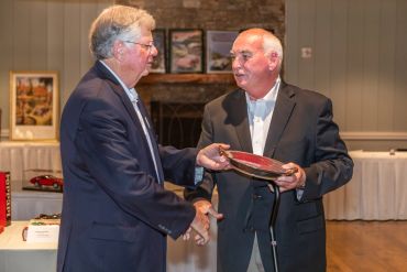Two men exchanging a decorative plate.