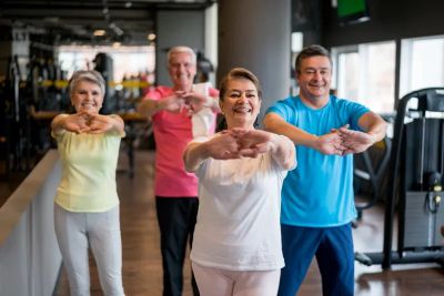 Group of elderly people exercising in a gym.