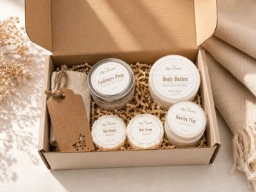 Natural skincare gift set with body butter, soap, clay, and candle in a rustic box.