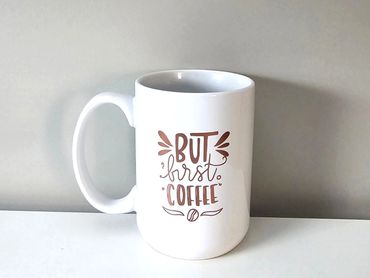 White mug with the text 'But first, coffee' on it.