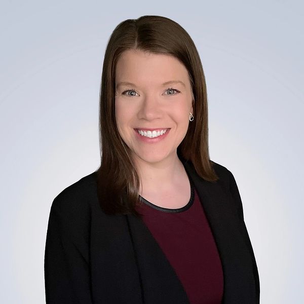 Professional woman with a warm smile in business attire.