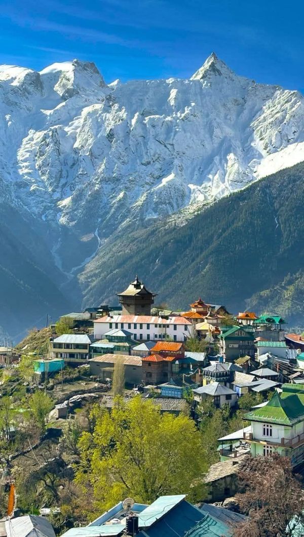 Village nestled by snow-covered mountains.