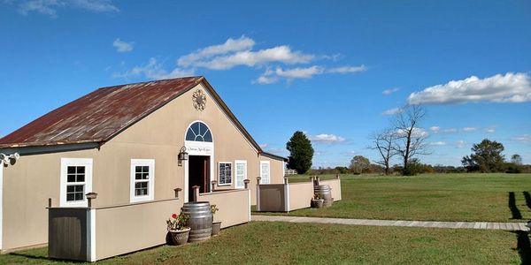 A picture of Chateau MerrillAnne's tasting room. The old barn style building has seating out front.