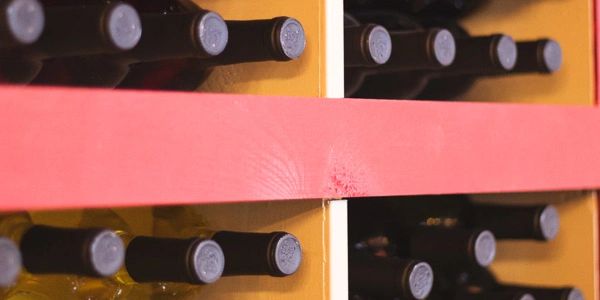 A picture of the wine rack behind the tasting bar with bottles of wine neatly stacked.