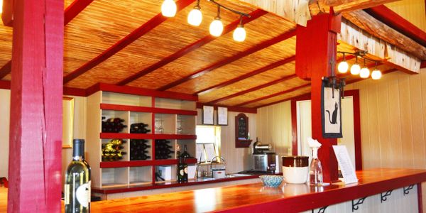 A picture of the wine bar at Chateau MerrillAnne. A shiny wood top is highlighted by red trim.