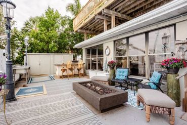 Cozy outdoor patio with seating and fire pit under a wooden deck.