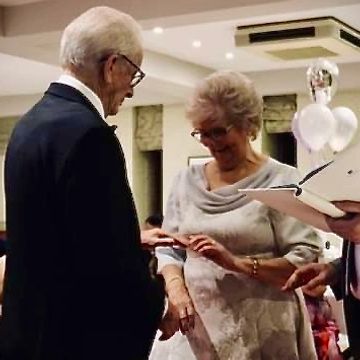 elderly couple exchanging rings at their renewal of vows ceremony