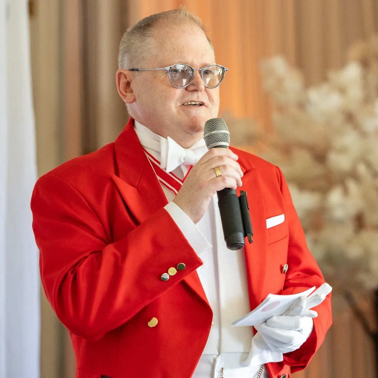 Toastmaster man in red jacket with microphone