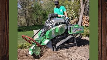 Man using a stump grinder to remove a tree stump