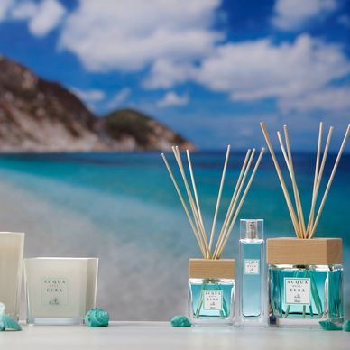 full acqua dell elba Home Fragrances range with beautiful turqoise ocean in the background