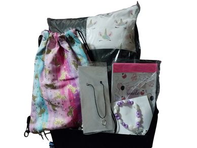Colorful unicorn gift set with pillow, bag, necklace, and bracelet.