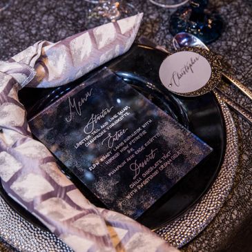 Plates, cutlery, and place card at a Fueled Events event.