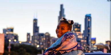 A little girl sitting on top of a car at a CHI-Together event.