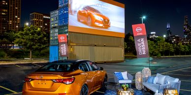 A 2021 Nissan Sentra parked in front of a movie screen at CHI-Together's Drive-In Date Night event.