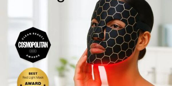 Woman wearing a black hexagonal red light therapy facial mask.