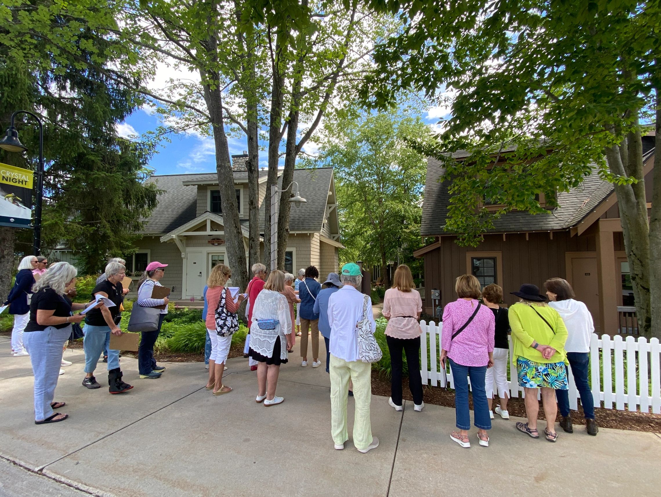 Group of people attending an outdoor event near houses.