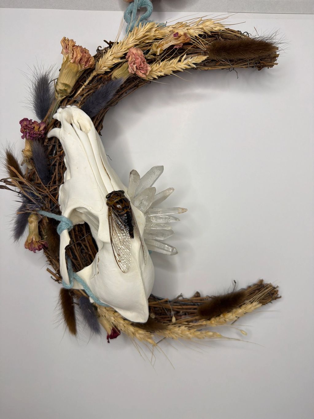 Wreath with skull, dried flowers, crystals, and cicada.