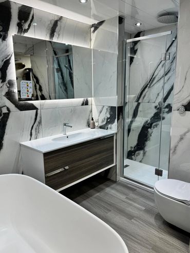 Black and white marble tiles display including a wall hung vanity unit and wall hung toilet