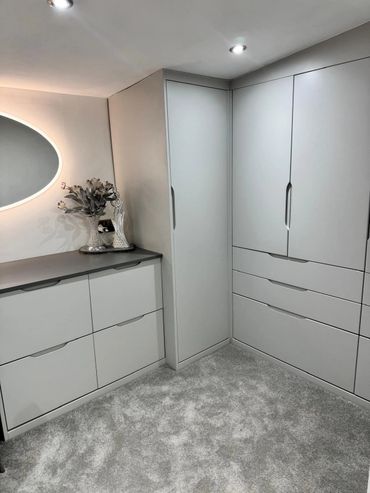 Grey handle less fitted wardrobes including half height racking and drawer system.