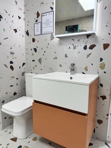 Contemporary bathroom display with a warm terracotta wall hung vanity unit and close coupled toilet
