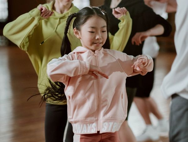 Young girl joyfully dancing in a class.