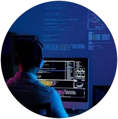 Person coding in a dark room with multiple screens showing data and code.