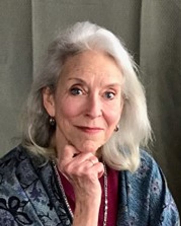 Elderly woman with white hair, resting her chin on her hand.