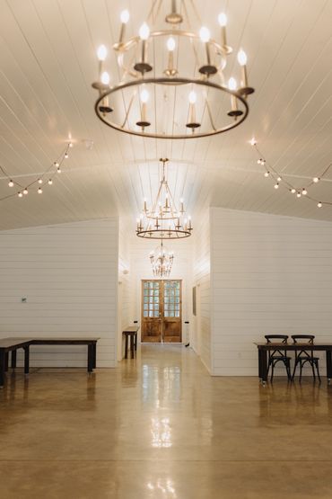 Modern white reception wedding venue at Firefly Lane, with beautiful romantic chandeliers.