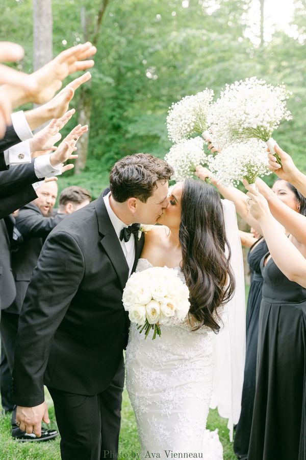 Black and white bridal party wedding portraits with baby's breath bouquets, celebrating newlyweds.