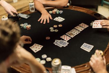 Groom and groomsmen playing poker in the onsite getting-ready groom's suite at Firefly Lane.