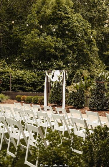 The Garden wedding ceremony site at Firefly Lane with white garden chairs and a stunning arch.