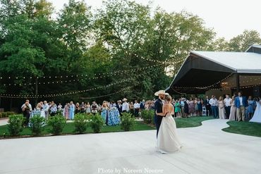 Bride and groom first dance on the patio outside at the barn wedding venue at Firefly Lane Weddings.