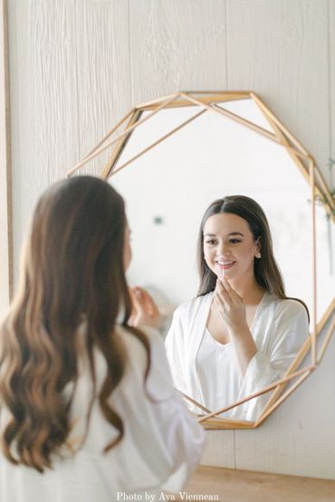 Bridal portraits in the bridal suite. Bride getting ready for her wedding ceremony in a bridal robe.