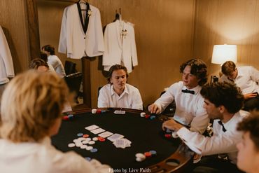 Groomsmen playing poker in the groom's suite before the wedding at the chapel.