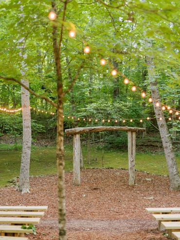 The Enchanted Forest is an outdoor ceremony location at Firefly Lane, adorned with string lights.