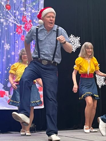 Man in Santa hat dancing.