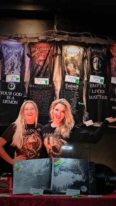 two smiling sales women at a band merchandise booth