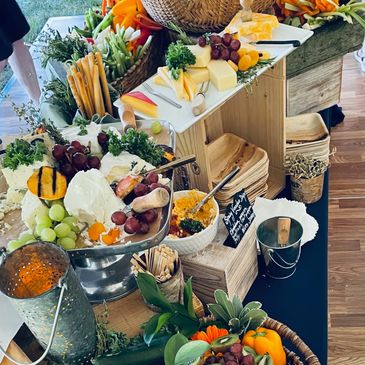 Grazing display with vegetables, cheeses, crackers, breads, set up for cocktail hour at wedding.