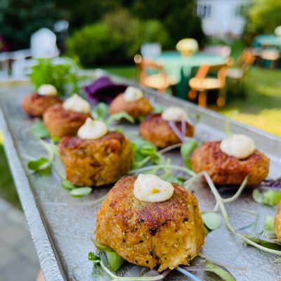 Mini Maine crab cakes with remoulade set on a silver passing tray for a cocktail party.