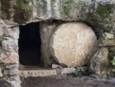 Stone tomb entrance with large round stone rolled aside.