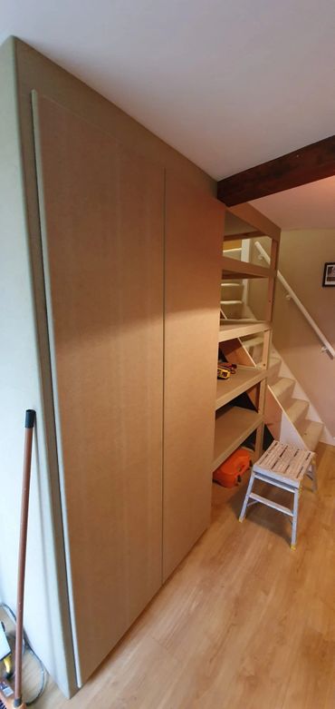 Custom under-stairs storage cupboards and shelving by Sutton Building Services.