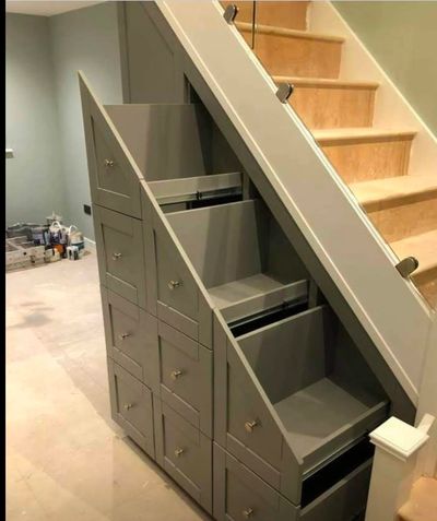 Custom storage drawers built under a staircase for efficient space use.