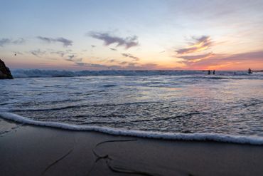 sunset at the beach with small waves in the foreground