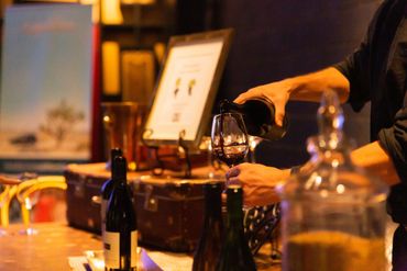 wine tasting setup showing red wine being poured into a glass
