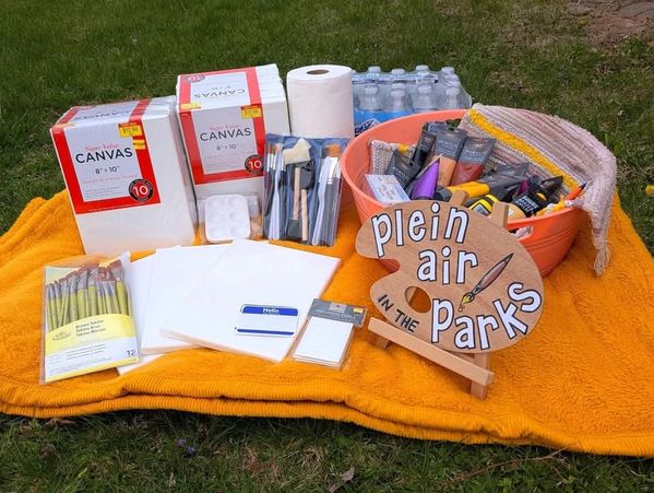 Outdoor painting supplies on a blanket.